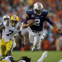 Auburn quarterback Cam Newton sprints with the football as LSU defender Patrick Peterson pursues across the green field.