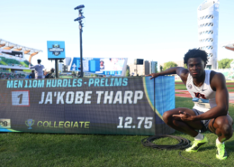 Ja'Kobe Tharp crouches beside the results board after running 12.75 in the men’s 110m hurdles prelims.