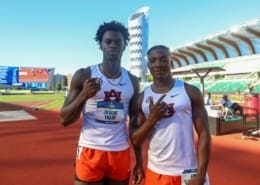 Ja’Kobe Tharp and Kayinsola Ajayi stand on the track in Auburn uniforms, posing at a stadium after their NCAA wins.