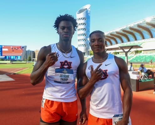 Ja’Kobe Tharp and Kayinsola Ajayi stand on the track in Auburn uniforms, posing at a stadium after their NCAA wins.